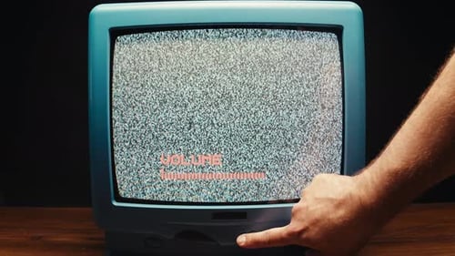Hand Adjusting Volume on Retro Television with Static