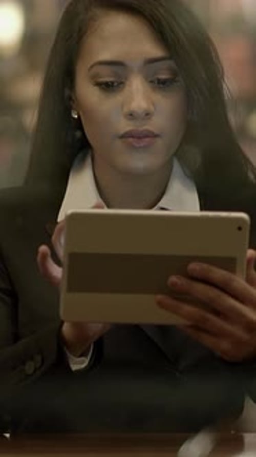A Focused Businesswoman Skillfully Using a Tablet in a Contemporary and Stylish Setting