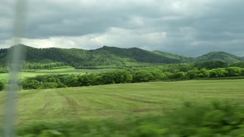 Green Mountain View Through Window of Moving Vehicle, Dramatic Sky, Japan