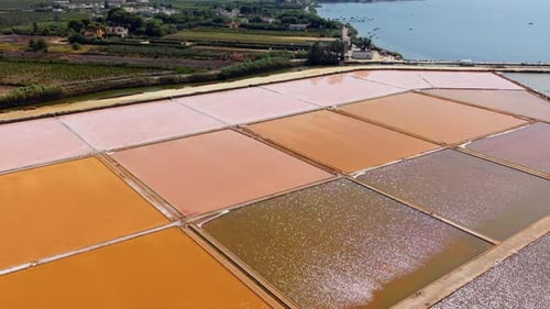Aerial drone view of colorful salt pans in Sicily near sea