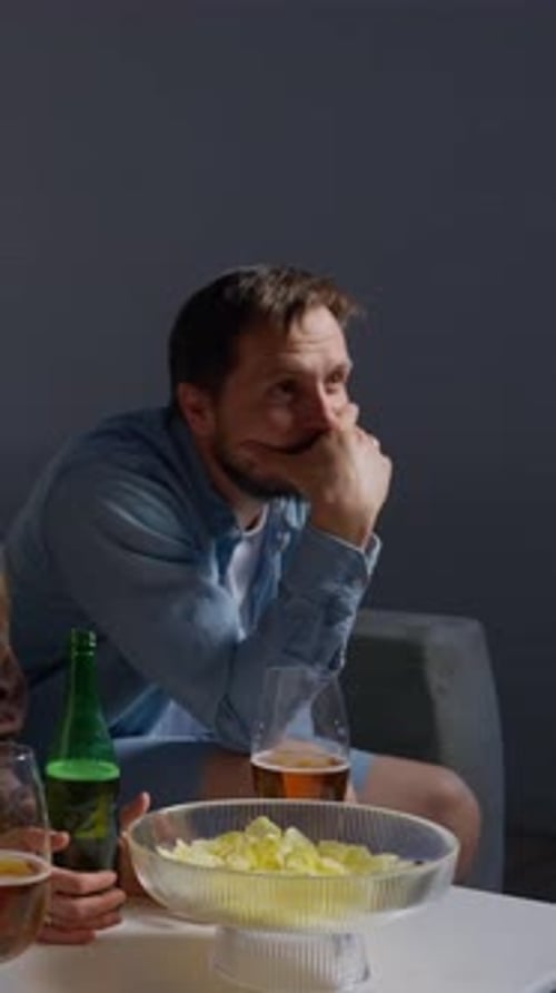 Emotional Moments of Football Fans Watching a Game in a Living Room Showing Intense Anticipation