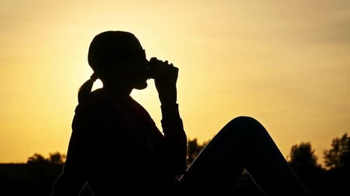 Young Woman Drinks Warm Coffee at Beautiful Sunset and Enjoys Life Slow Motion