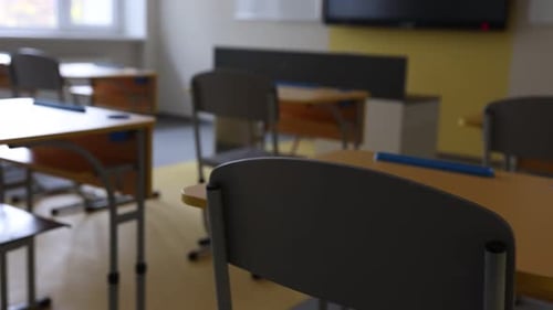 Stylish classroom with desks and chairs at school, closeup. Camera moving left