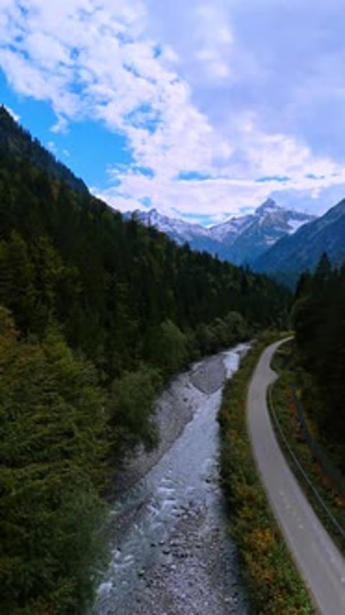 Footage above the narrow mountain river and highway passing along it.