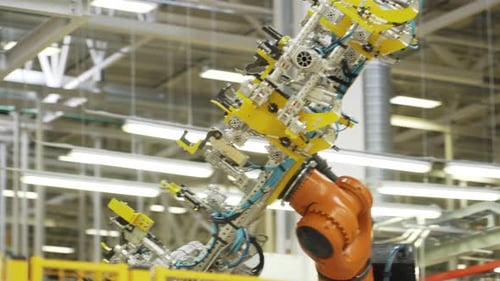 Brazo robótico en movimiento en una planta de ensamblaje de automóviles