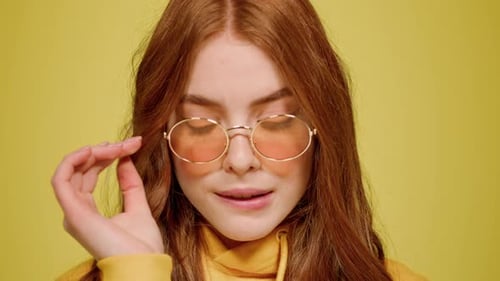 Attractive Woman Posing in Round Glasses on Yellow