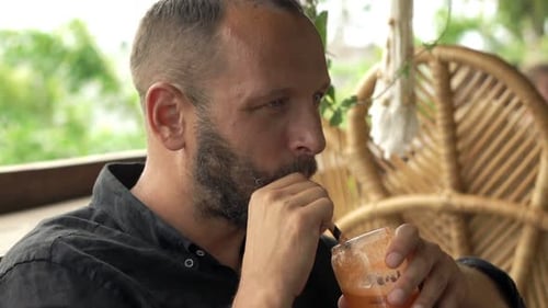 Man Drinking Cocktail Sitting In Cafe