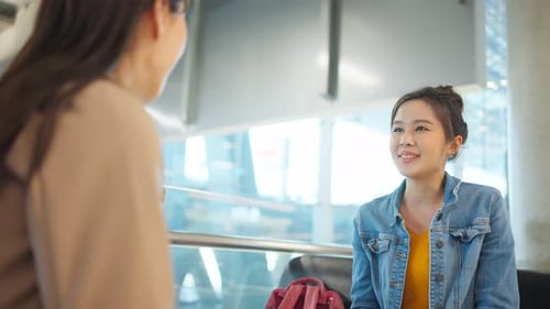 Passageira asiática esperando o embarque do avião no terminal do aeroporto.