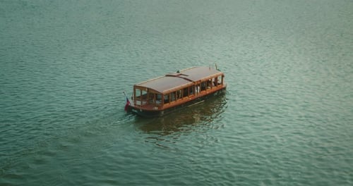 Wooden Boat Sailing on Vltava River in Prague at Evening Light