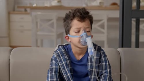 Ill School Age Black Boy in Nebulizer Mask Doing Asthma Breathing Treatment