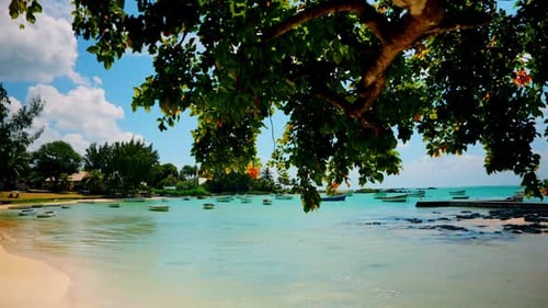 Tropical empty beach. Small wooden fishing boats anchored close to the shore. Unspoiled exotic beach
