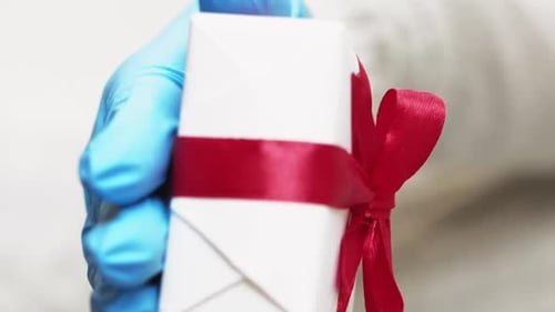 Hand in Glove Holding a Wrapped Gift