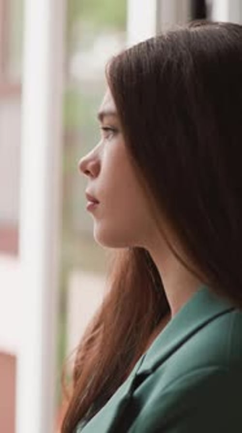 Les yeux d'une femme s'attardent sur les pluies régulières à l'extérieur