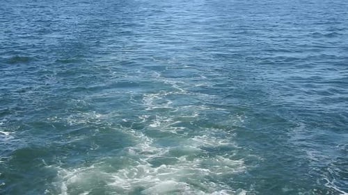 wake of water seen from behind of fast moving motor boat in a clear sky day,Blue sea , water surface