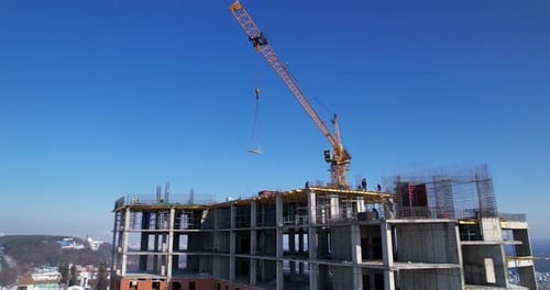 Tower Crane Lifting a Concrete Slab at a Construction Site Aerial Shot
