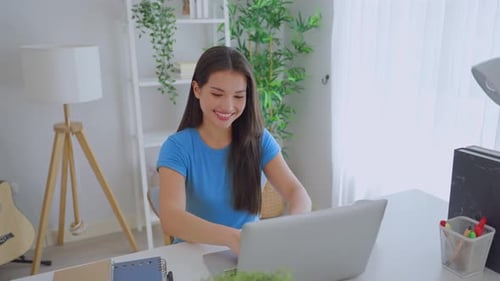 Woman Smiling Working on Laptop at Desk