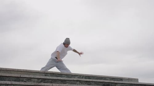 Young Adult Performs Acrobatic Dance Moves on Steps