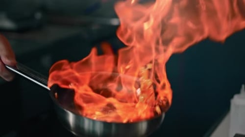 Chef Cooking Food with Flames in Frying Pan