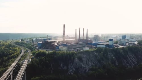 Industrial Plant Emitting Smoke From Chimneys on Hilltop