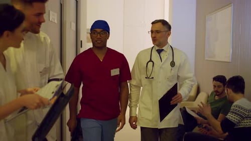 Doctors Walk and Talk in Hospital Hallway
