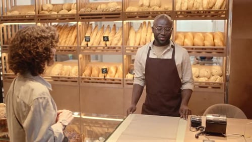 Bakery Worker Talking with Female Customer at Counter