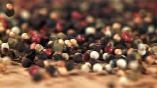 Close Up of Colorful Peppercorns Pouring onto Wood