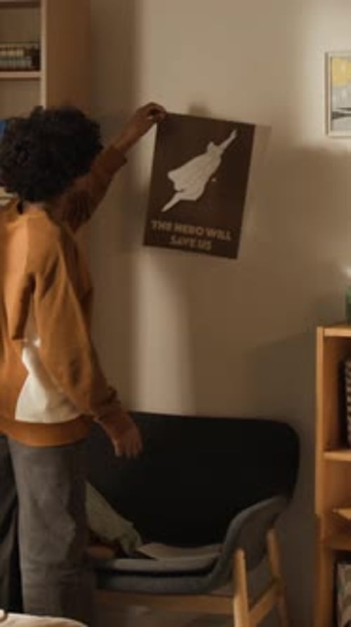 Vertical of Young Student Replacing Superhero Poster with School Lesson Schedule