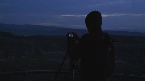 Silhouette eines Fotografen, der vor Sonnenaufgang am Bryce Point einen Zeitraffer macht.