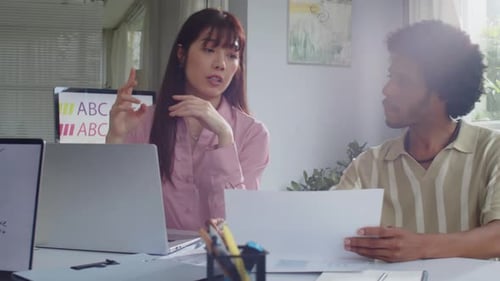 Diverse Coworkers Discussing App Design at Office Desk