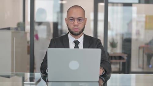 Focused Man Working on Laptop in Office