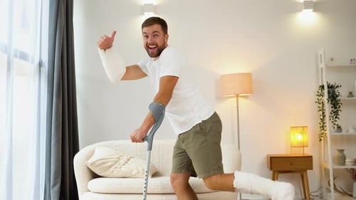 Happy Man Dancing with Crutches and Cast
