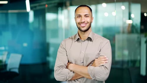 Portrait young adult businessman employee man in shirt smiling and looking at camera in office.