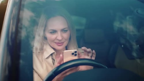 Woman Looking at Phone in Car