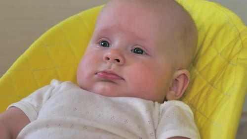 Sweet Infant Relaxing in Yellow Baby Chair