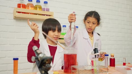 Young scientist boy and girl enjoy to learn and practice to do the experiment in school with tools