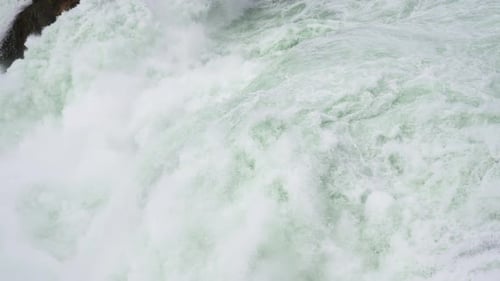 Vue au ralenti d'une cascade précipitée créant des éclaboussures et de la mousse spectaculaires