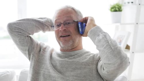 Smiling senior man talking on his phone indoors