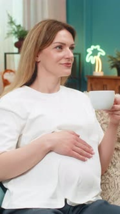 Pregnant Woman Relaxing at Home Drinking Tea