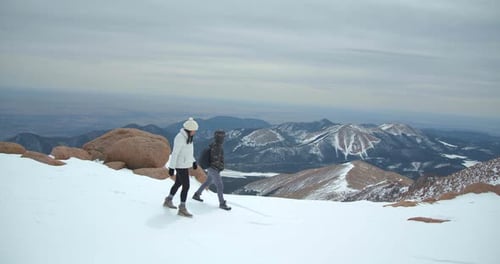 Couple Climbing Up Mountain, Hiking Rocky Mountains in Snow Adventure