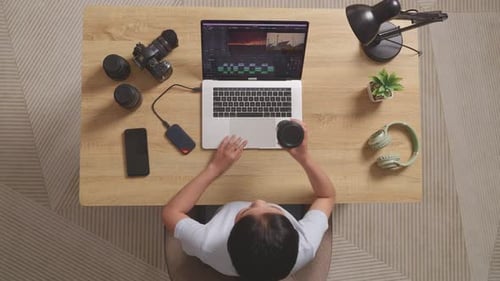 Top View Of Woman Editor Drinking Coffee While Sitting In The Workspace Using A Laptop Editing