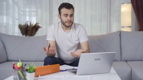 Stressed Man Working From Home On Laptop