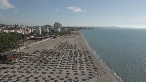 Beach parasols on sunny Adriatic seashore day, but very few tourists