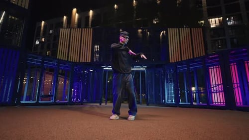 Talentierter männlicher Tänzer mit schwarzer Sonnenbrille tanzt HipHop und JazzFunk im Nachtporträt