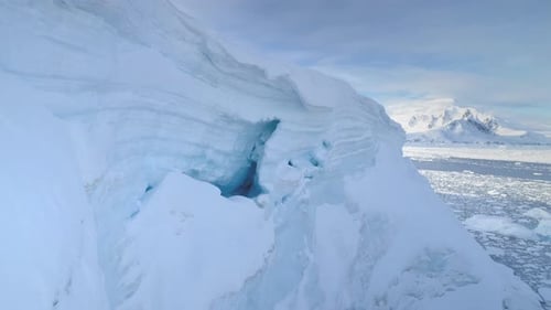 Blue Ice Cave in White Glacier on Antarctic Peninsula Aerial Shot Closeup