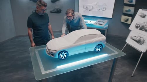 Two Automotive Developers Make Design Corrections in Sculpture of Prototype Car