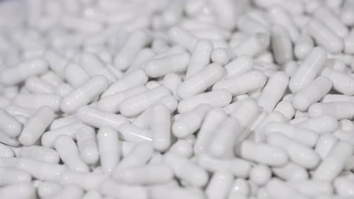 Pills capsules falling onto the surface