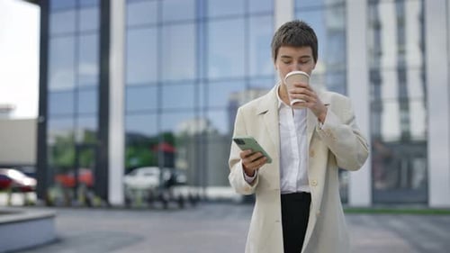 Stylish Woman Drinks Coffee and Uses Phone