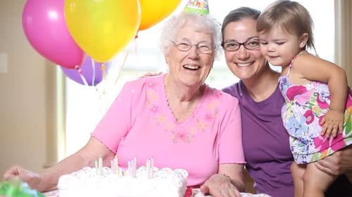Happy grandmother with family celebrating birthday indoors