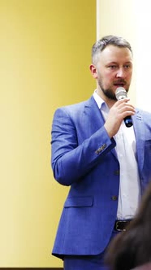 Man Speaking Into Microphone at a Conference