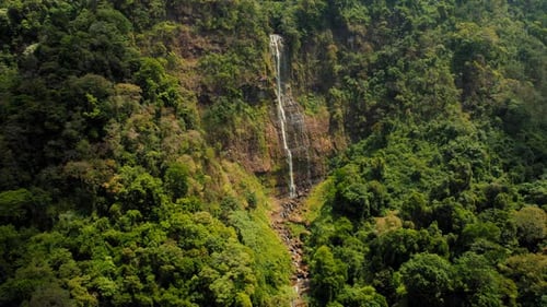 Aerial View of High Waterfall Flowing By Dense Rainforest Vegetation Costa Rica